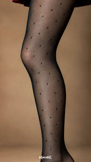 A close-up shot of a woman wearing black sheer-effect polka dot stockings, highlighting the fine transparent-look finish, evenly spaced dot pattern and smooth fit around the knee and leg - Muselot