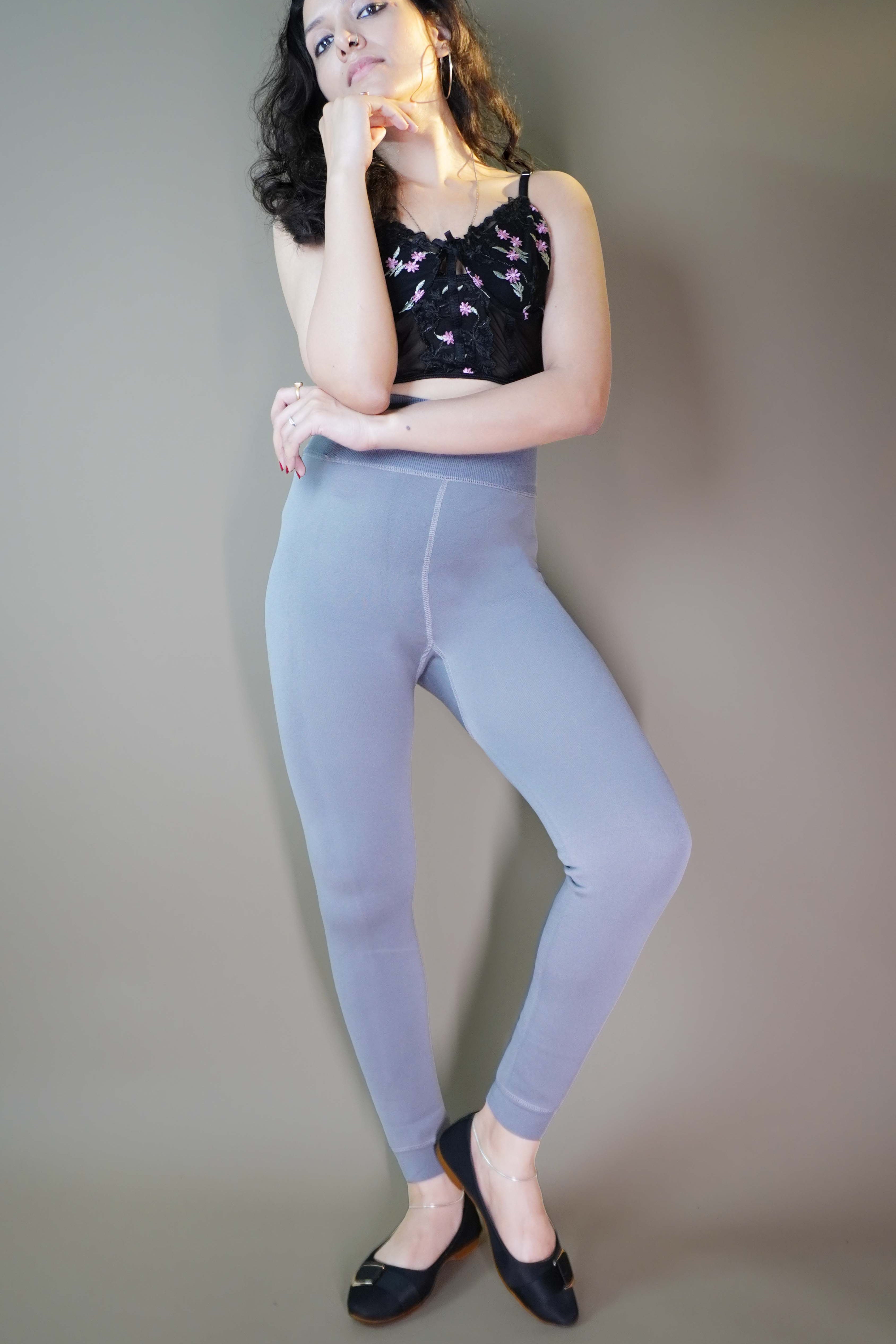 A model, wearing stylish grey warm tights,showcasing their chic, form-fitting design that offers both warmth and style. The grey color highlights a sleek, modern look, making these tights a perfect addition to any outfit for colder days. -Muselot