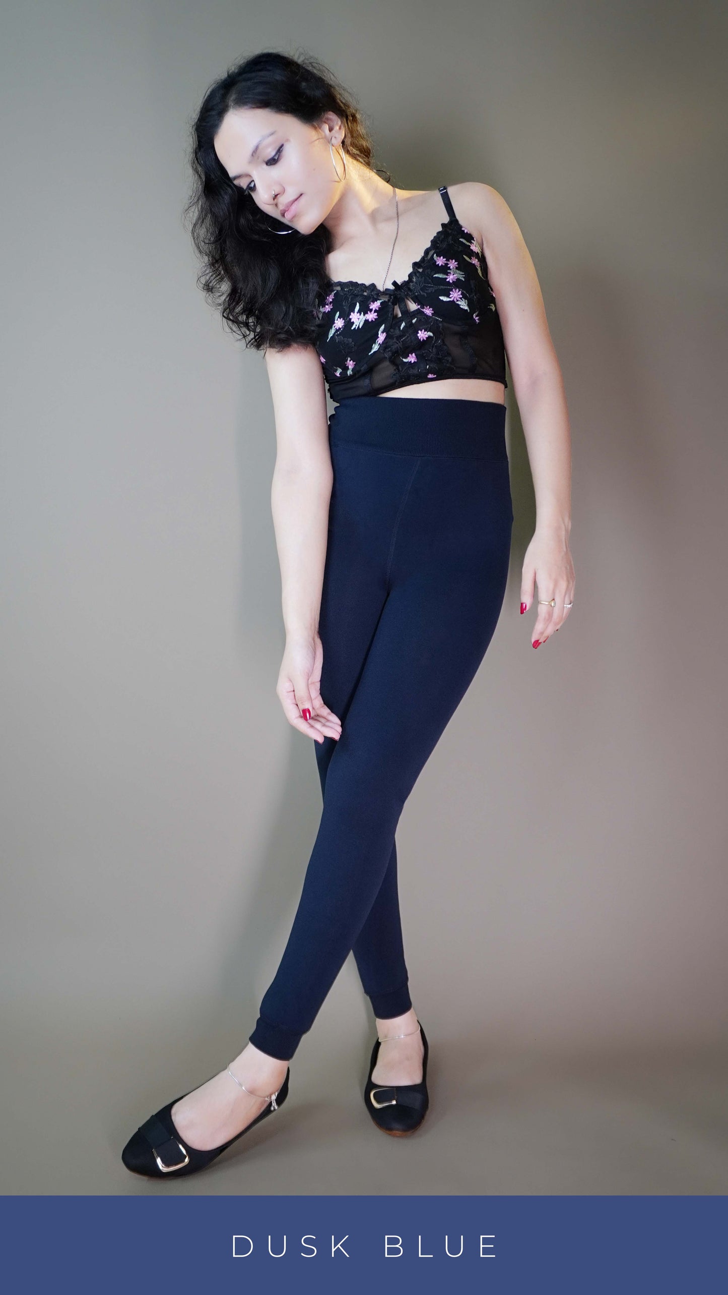 A model wearing thermal navy blue tights paired with a chic floral crop top, showcasing the tights impeccable fit and insulating thermal fabric. The deep navy blue tone offers a sleek, sophisticated look, while the design ensures warmth and comfort during colder days. Perfect for blending style with practicality. -Muselot