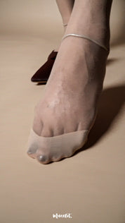 A close up of foot wearing sheer nude stockings, transparent pantyhose showing toe detail and fine 15 denier fabric texture - Muselot
