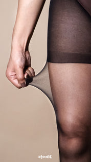 A model wearing ultra sheer black stockings, close-up thigh shot with hand stretching the fabric on a warm beige studio background, highlighting 15 denier transparency, high elasticity, and smooth second-skin finish — Muselot
