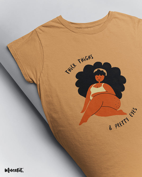 Thick thighs and pretty eyes design illustration printed t shirt in mustard yellow for body positivity by Muselot